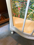 Vintage White Wooden Short Light Up Glass Display Cabinet With Tropical Wallpaper Background
