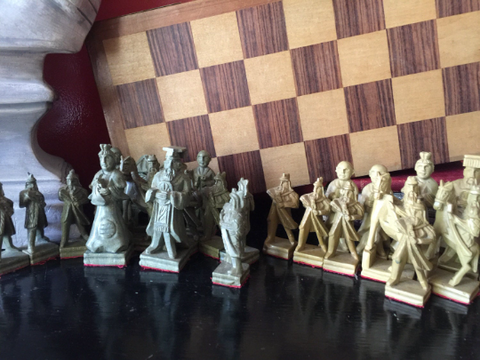 Collection of Stone Chess Pieces With Wooden Chess Board