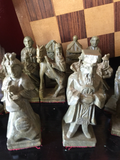 Collection of Stone Chess Pieces With Wooden Chess Board